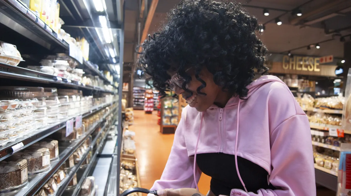 Un jeune adulte fait ses courses dans un rayon de supermarché.